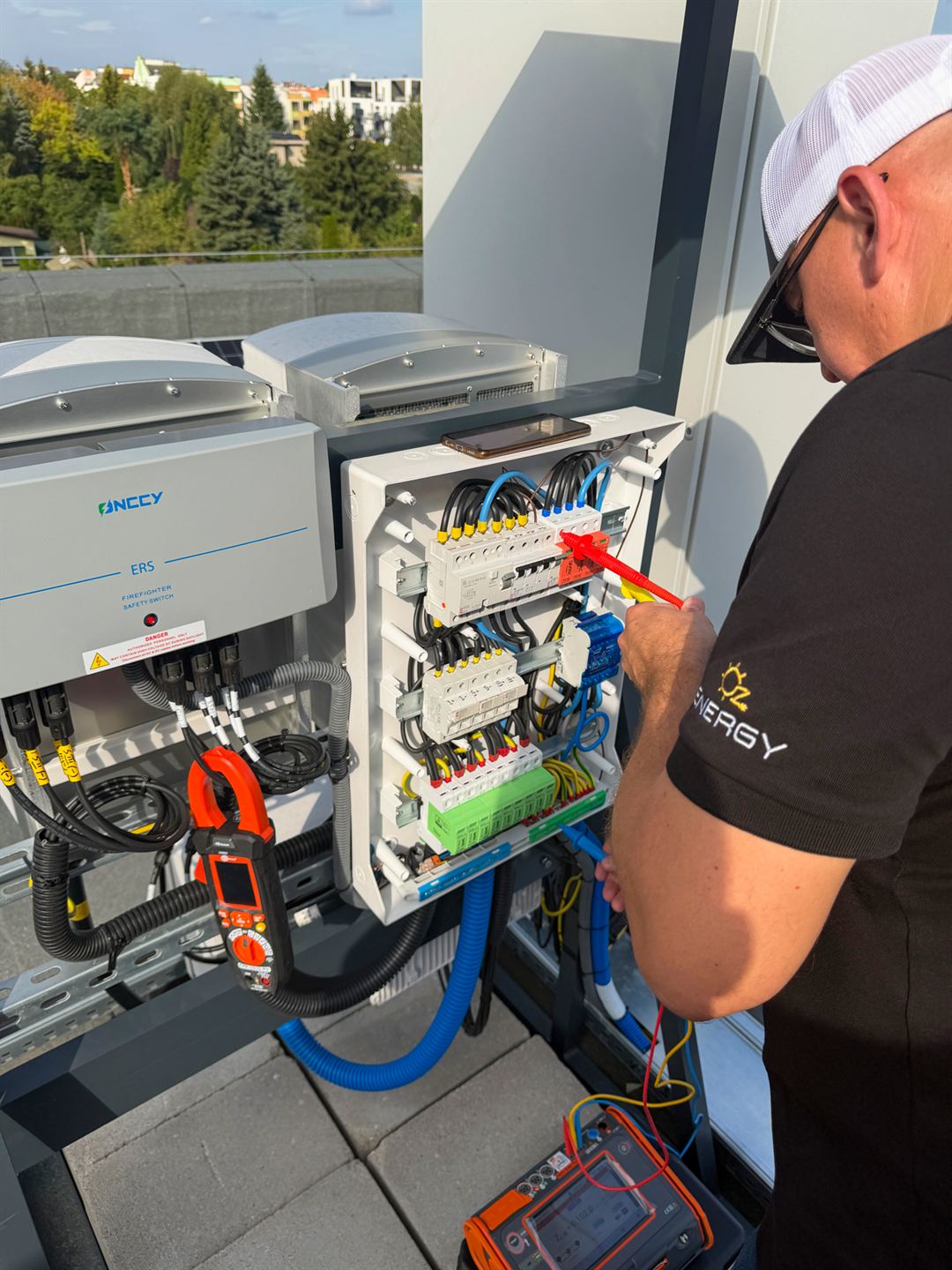 Technik OZEnergy wykonuje pomiar sondą w rozdzielnicy instalacji fotowoltaicznej
